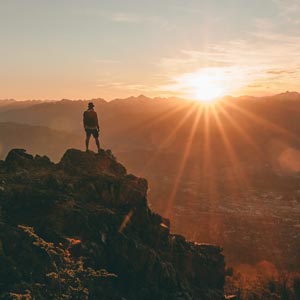 Person on top of the mountain during sunrise symbolising hope in the battle with emetophobia